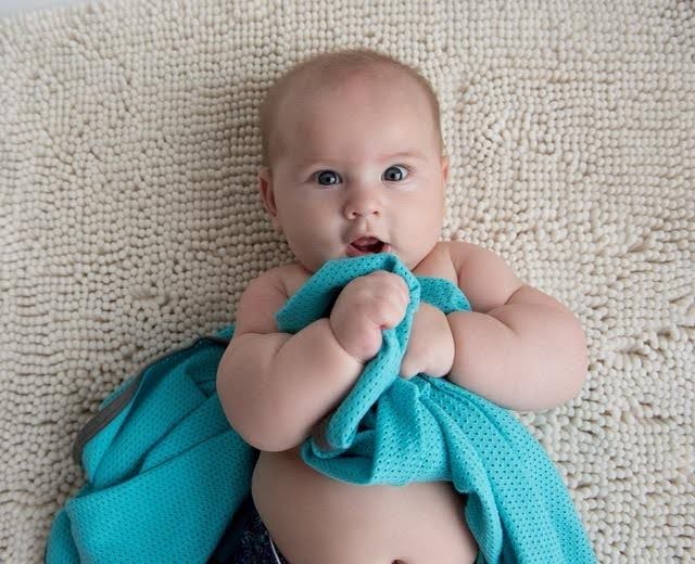 A baby swaddled in a soft blue blanket, peacefully resting