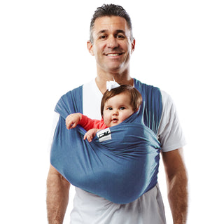 A man holds a baby securely in a Baby K'tan carrier, highlighting their close relationship.