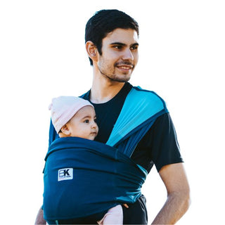 A man with a baby in a Baby K'tan carrier, showcasing a nurturing bond between them.