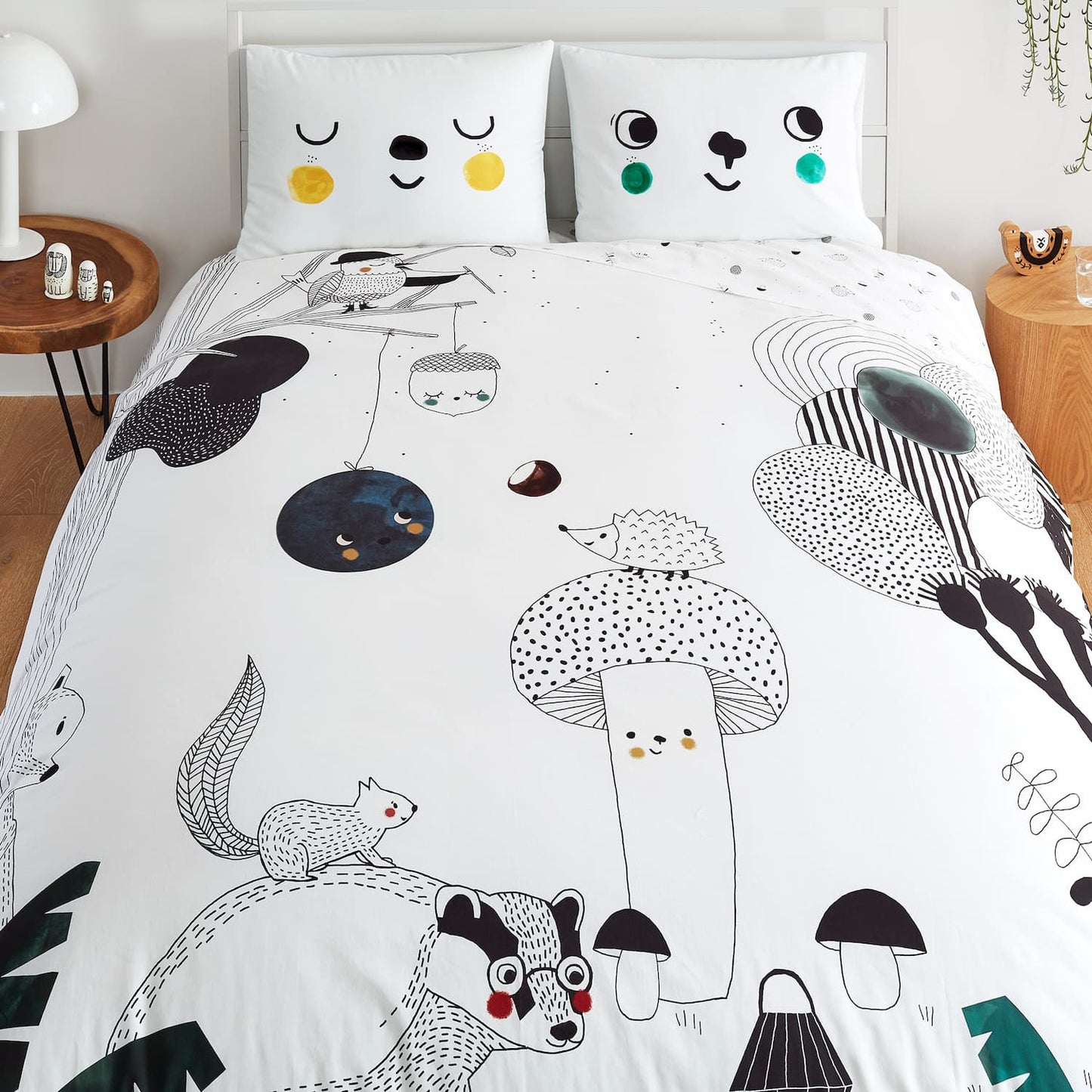 A bed featuring a white comforter adorned with a playful cartoon animal design, suitable for a child's room.