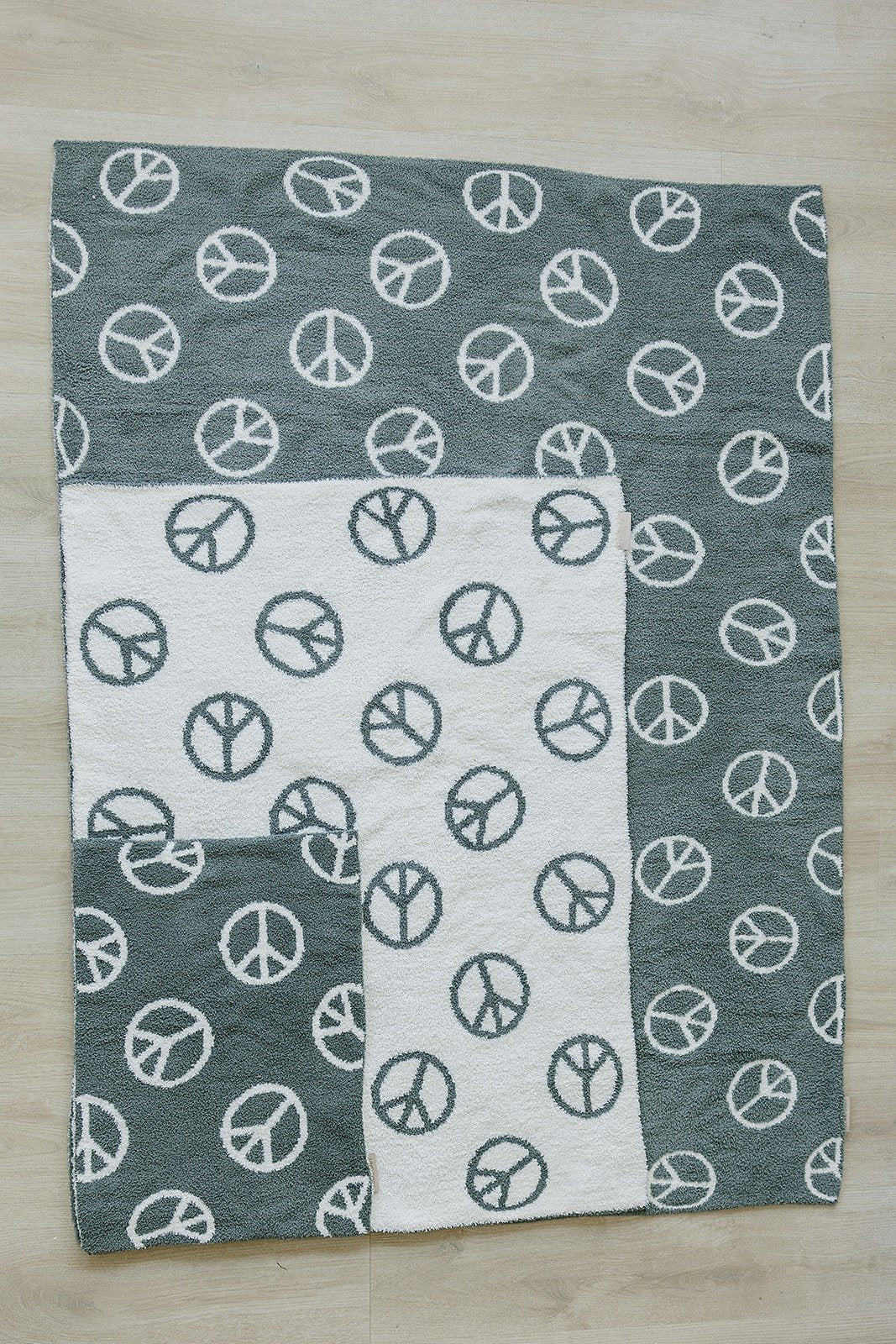 Blanket with peace symbol pattern on a wooden surface