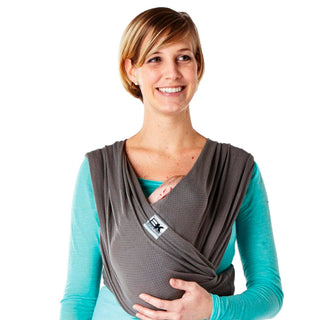 A person wearing a gray Baby K'tan Breeze baby carrier with a charcoal color shade over a teal top.