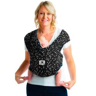 A person wearing a Baby K'tan Baby Carrier in a Sweetheart Black pattern with a infant inside.