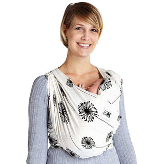 A woman holds her baby close to her chest in a Baby K'tan carrier featuring a dandelion pattern