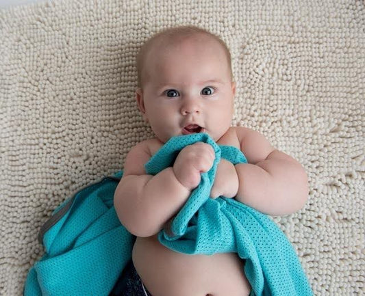 A baby swaddled in a soft blue blanket, peacefully resting