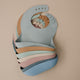 Stack of colorful baby bibs on a beige background