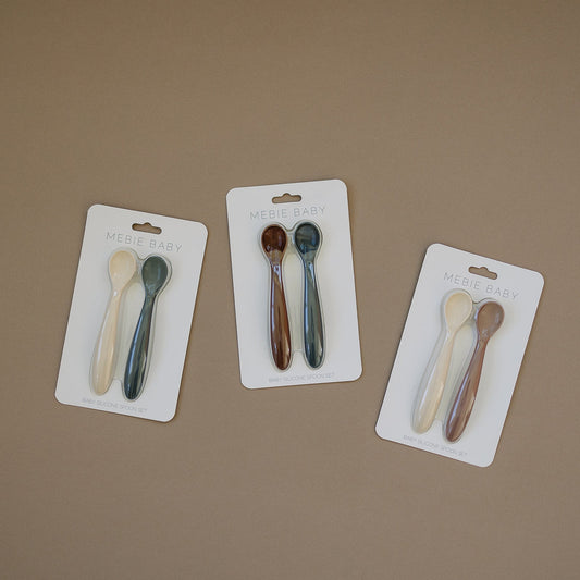 Set of colorful spoons on a beige background