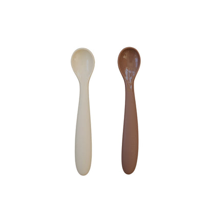 Two spoons, one beige and one brown, on a white background