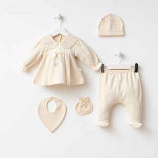 Baby clothing set including a dress, pants, hat, and bib on a white background
