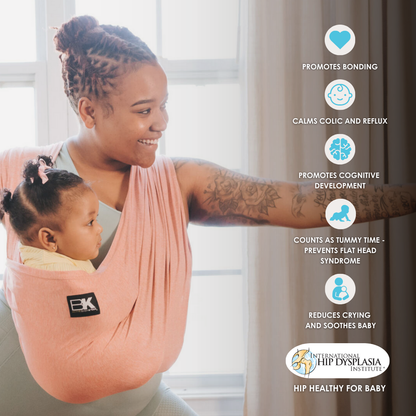 A woman with a baby in a pink Baby K'tan carrier, illustrating a close and affectionate connection.