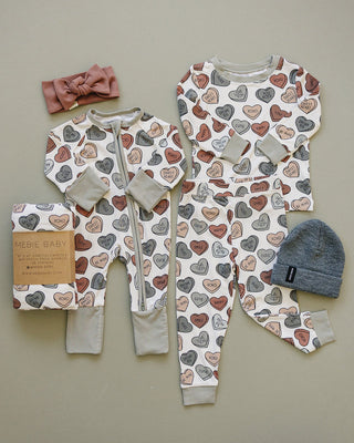 Baby clothing set with heart pattern on a neutral background