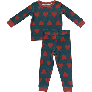 Children's pajama set with red heart pattern on a teal background
