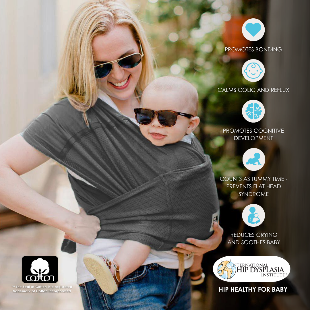 A woman with a baby secured in a gray Baby K'tan carrier, showcasing a nurturing embrace.