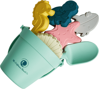 Set of colorful beach toys including a seahorse, starfish, and shark with a green container on a transparent background.