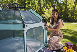 Woman setting up a pet pen next to a car in a park