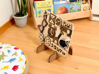 Wooden puzzle toy on a wooden floor with children's books in the background