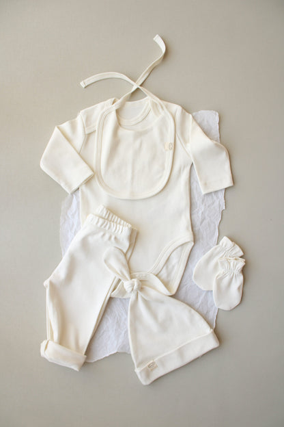 Set of white baby clothing on a gray background