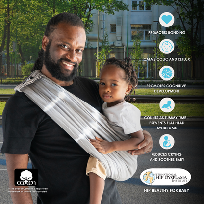 A man with a baby in a Baby K'tan sling, featuring the words "the best baby carrier" prominently.