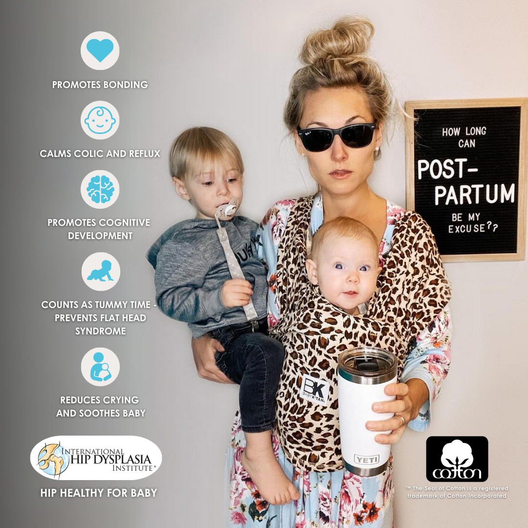 A woman with two children snug in a leopard print Baby K'tan carrier, embodying comfort and style in parenting.