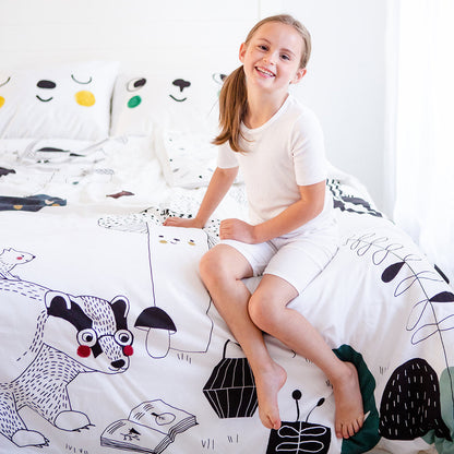 Young girl sitting on a bed with cartoon animal bedding