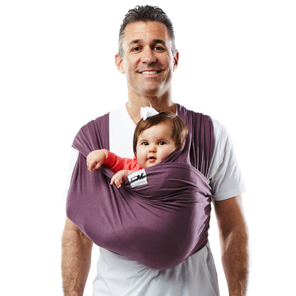 Man holding a baby in a purple sling against a white background