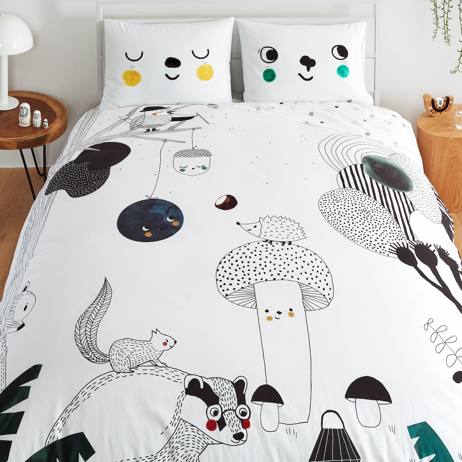 A bed featuring a white comforter adorned with a playful cartoon animal design, suitable for a child's room.