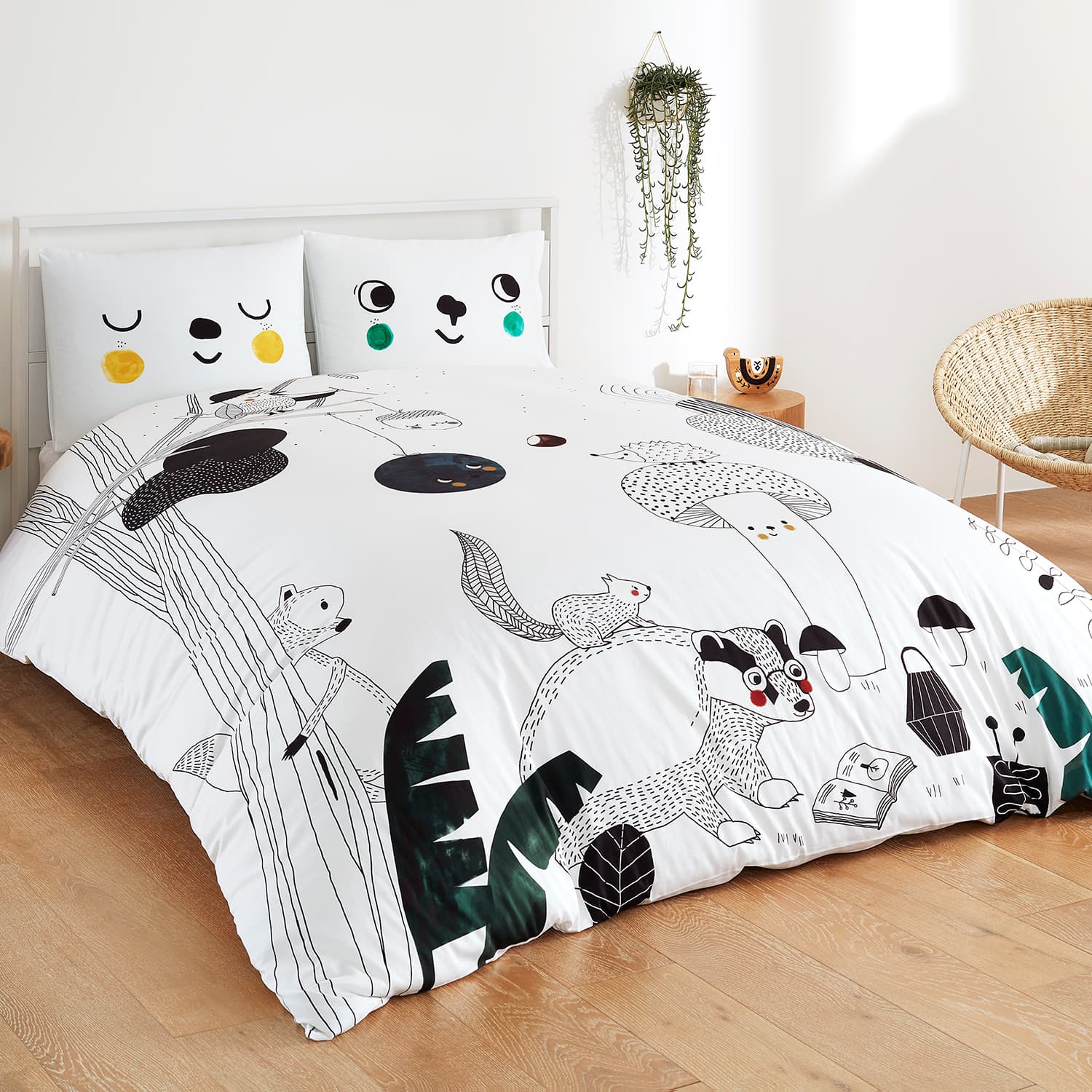 Bedding set with animal illustrations on a bed in a room setting.