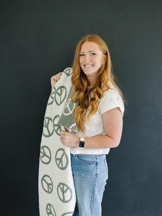 Woman holding a surfboard with peace signs against a dark background