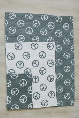 Blanket with peace symbol pattern on a wooden surface