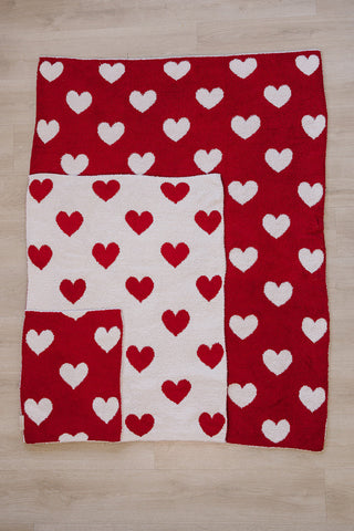 Red and white heart-patterned blanket on a wooden surface