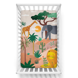 Crib with a colorful safari-themed blanket featuring animals and plants.