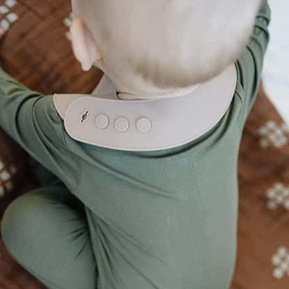 Person wearing a green outfit with a white collar featuring buttons.