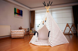 Children's playroom with a white teepee and wooden furniture.