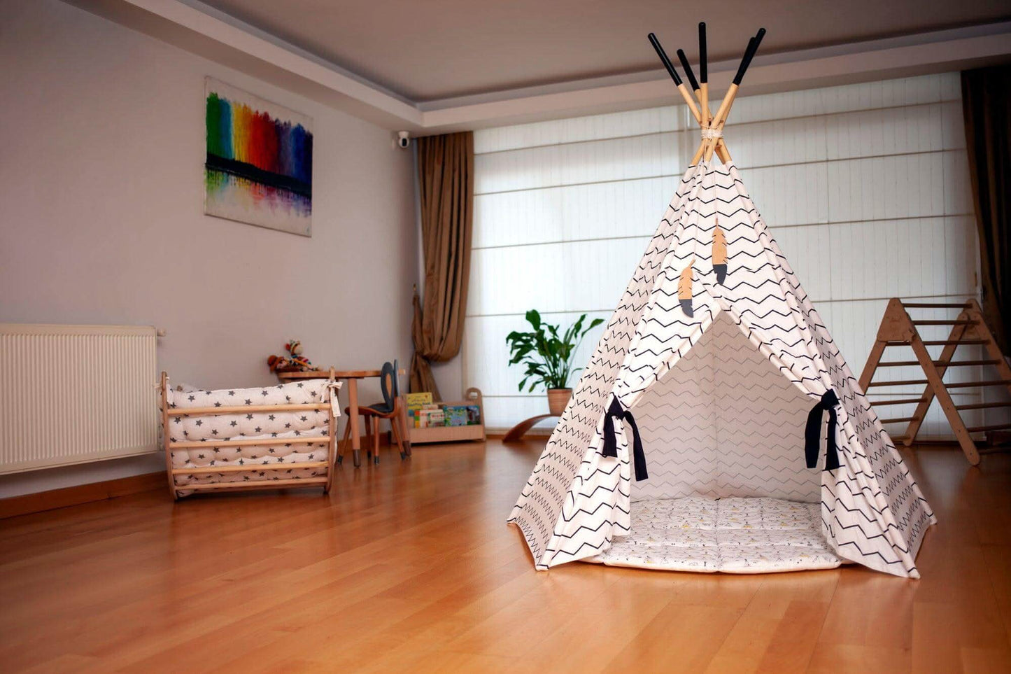Children's playroom with a teepee, wooden furniture, and colorful wall art.